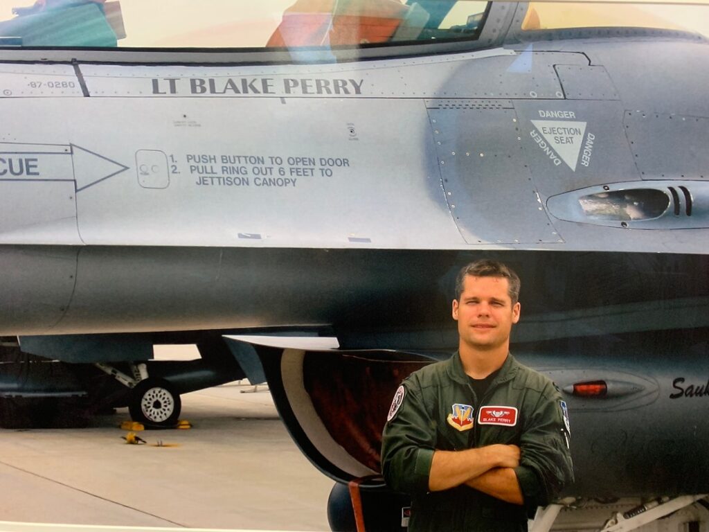 Dr. Blake Perry standing beside his fighter jet