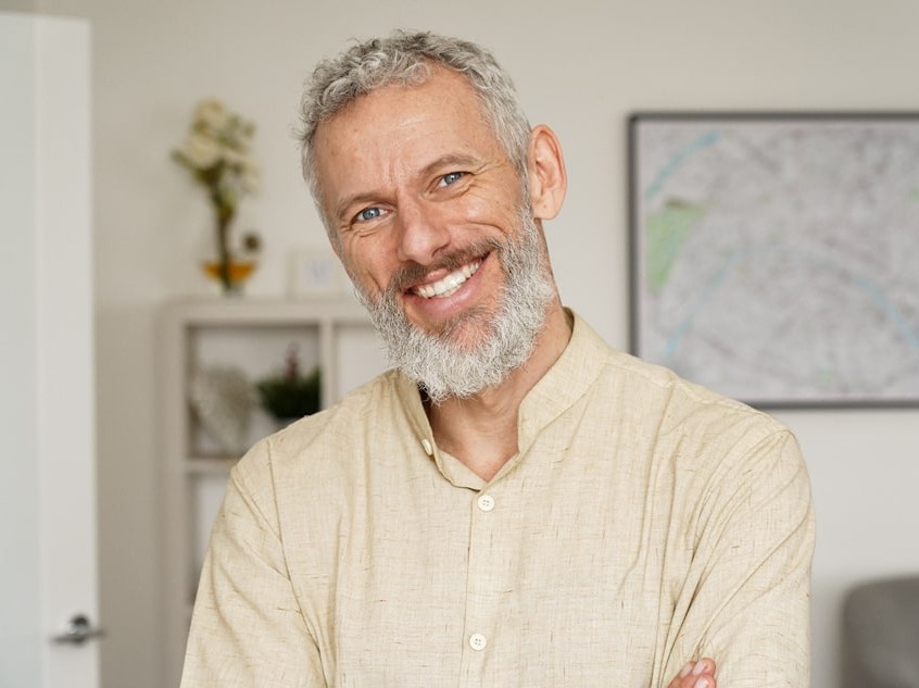 middle-aged man in white button up smiling