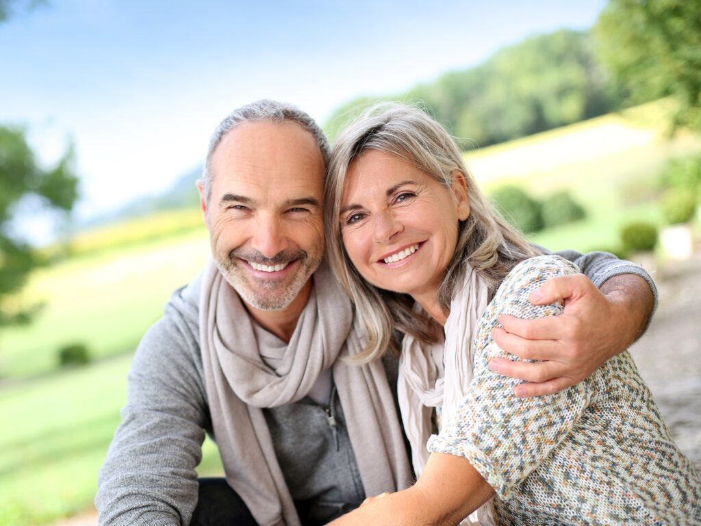 Mature couple smiling outside