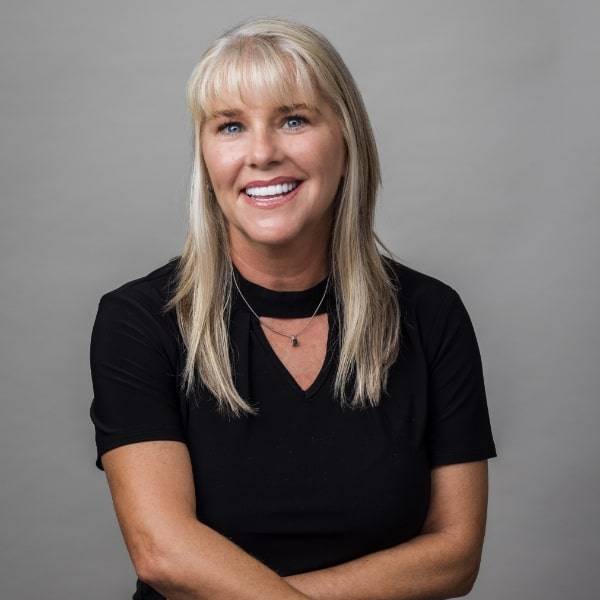 Blonde-haired woman looking into camera and smiling