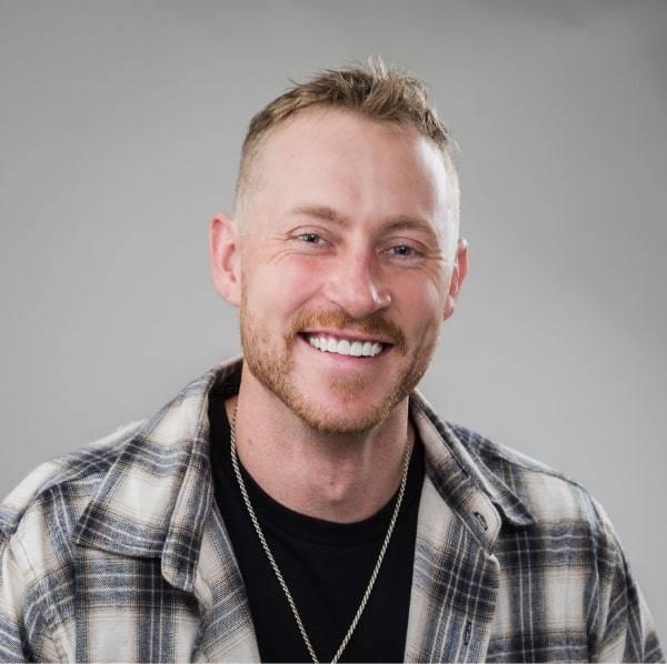 Man with short red hair looking into the camera and smiling