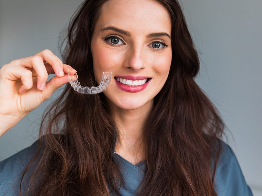 Woman holding clear aligner orthodontics